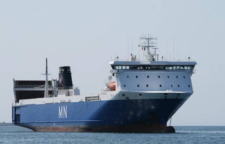 Un plano general de un barco azul y blanco fondeado en el mar