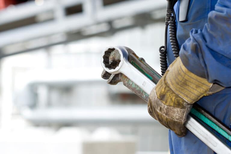 A close up of a maintenance worker holding tools getting ready for predictive maintenance
