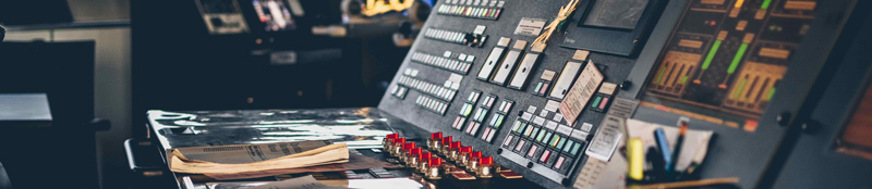 A close-up of the controls at the bridge on a maritime vessel with a manual laying in front