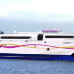 A close-up from the side on a Condor Ferries passenger ferry sailing through the calm sea