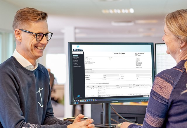 A picture of Julie and Hans talking about SERTICA at a desk with screens